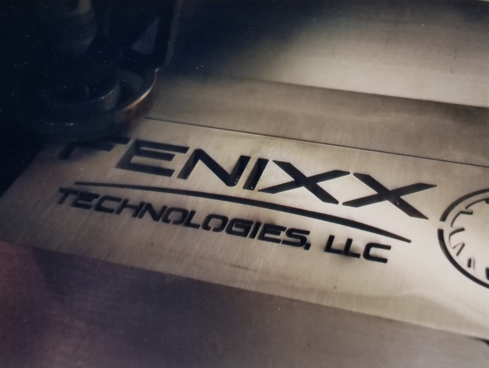 Fenixx waterjet machine cutting the company logo into steel plate